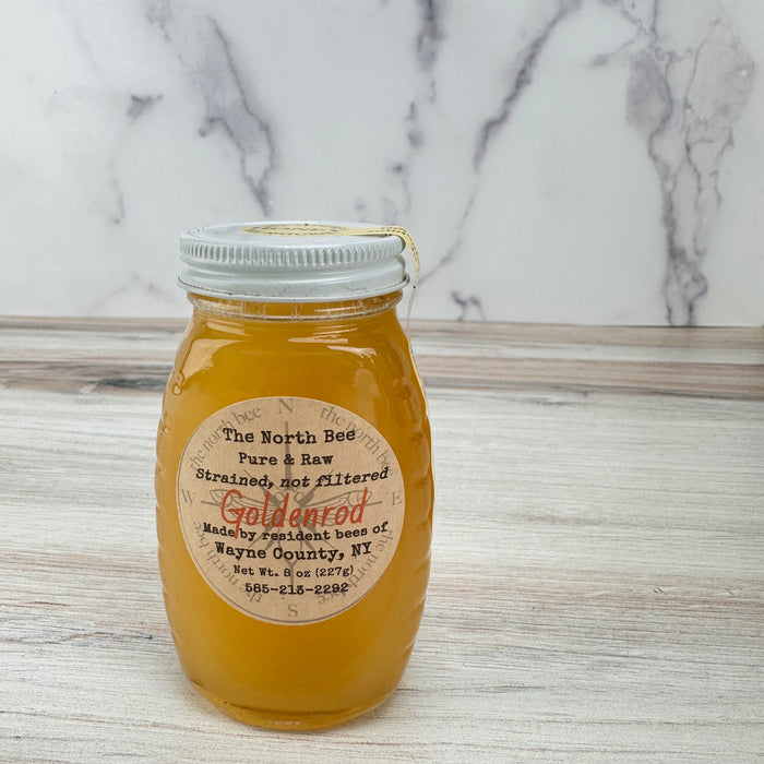 Jar of honey with a label on a marble countertop
