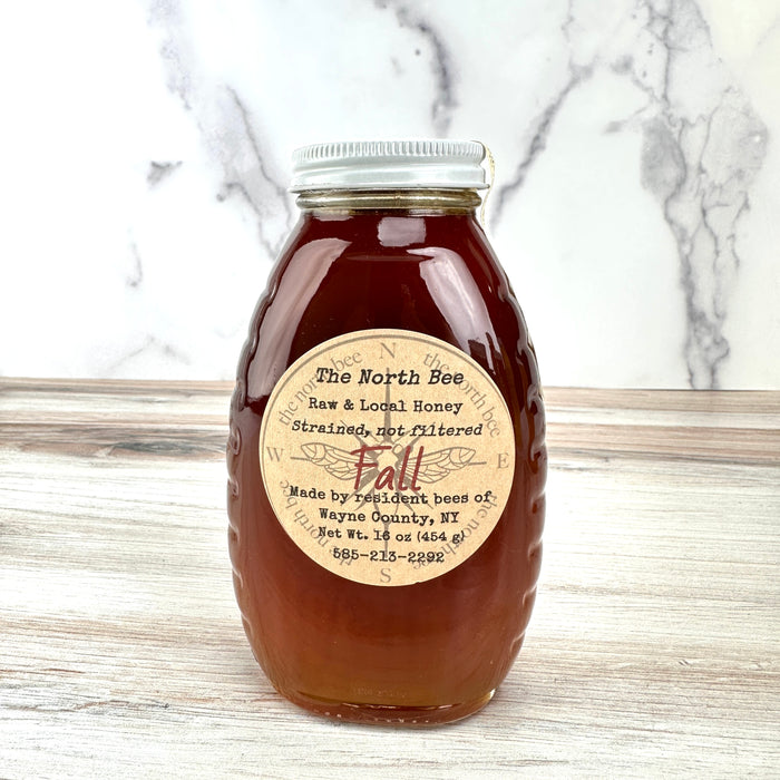Jar of honey with a label on a marble countertop