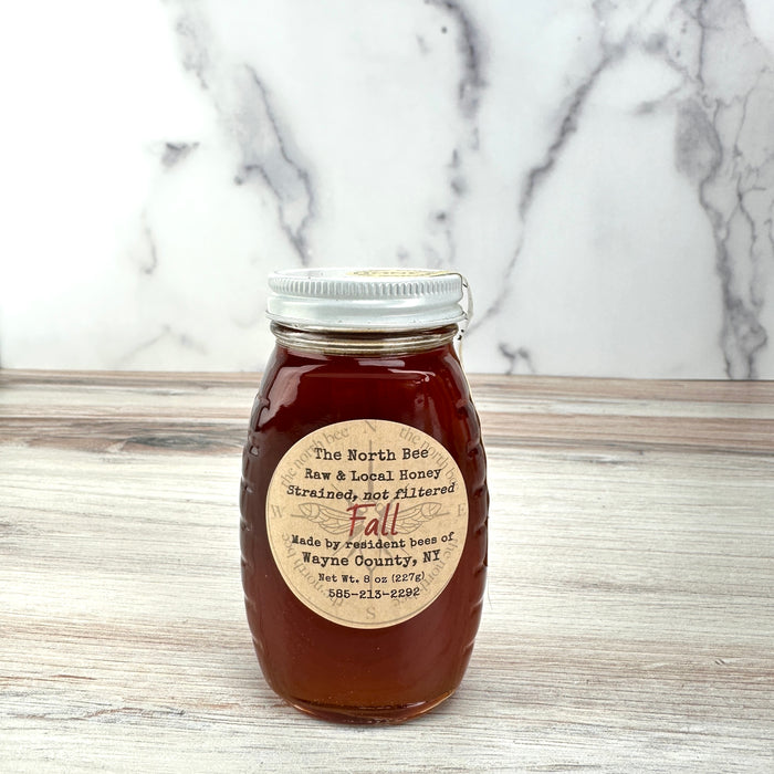 Jar of honey with a label on a marble countertop