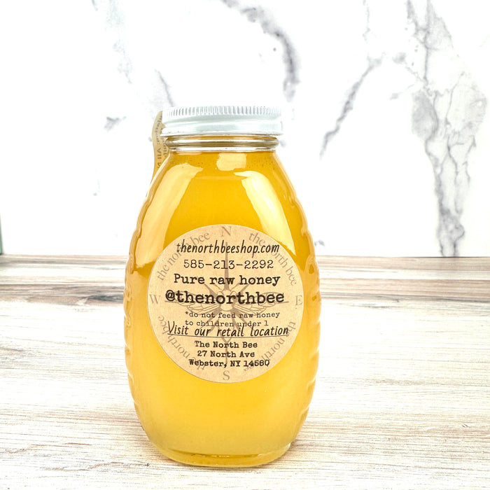 Bottle of honey with a label on a marble surface